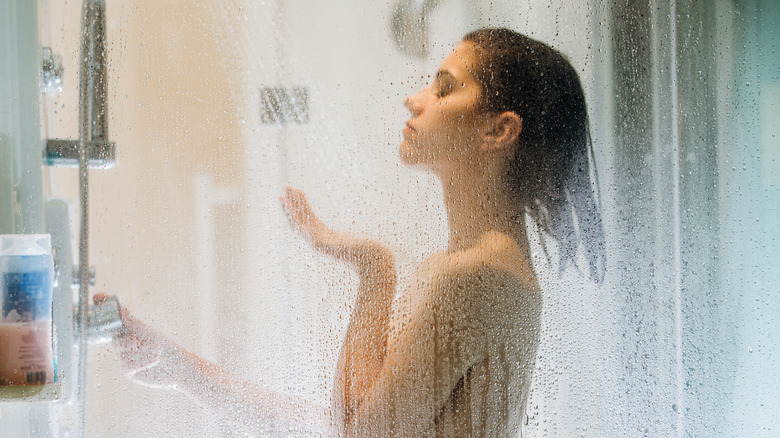 woman in shower adjusting temperature