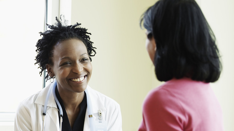 Woman talking to smiling doctor