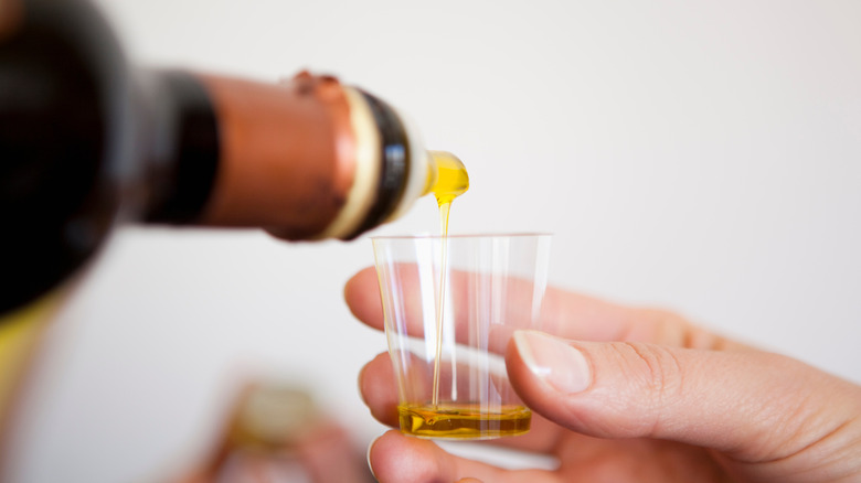 EVOO being poured in tasting cup