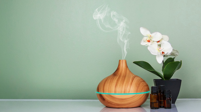 diffuser with orchid and essential oil bottles