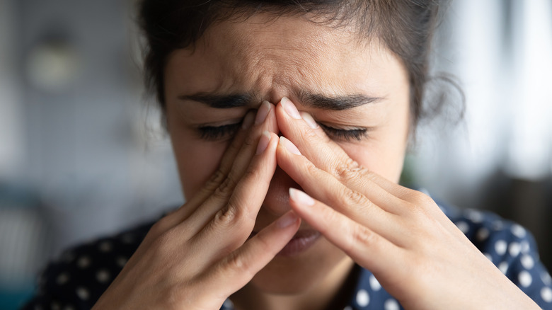 woman holding her face