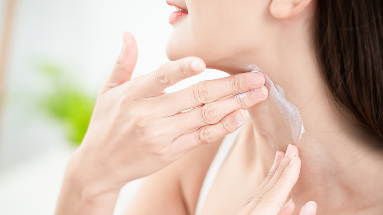 woman moisturizing her neck