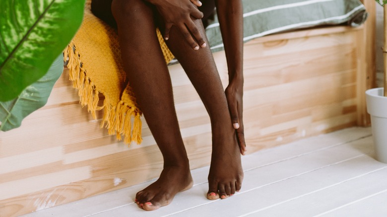 Seated woman holding foot