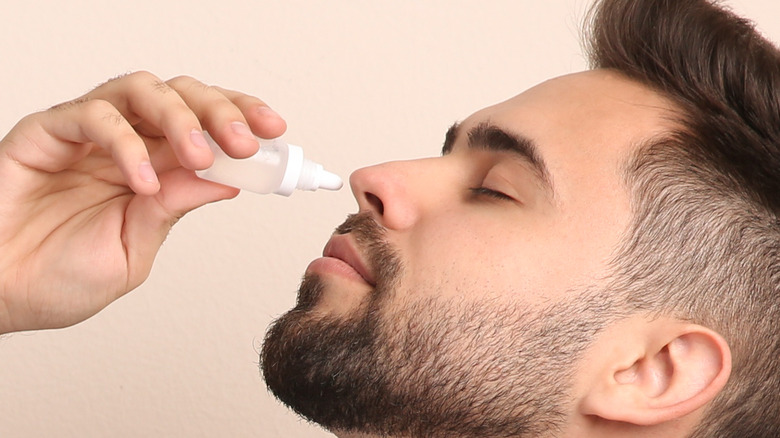 man using nasal spray 