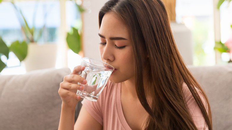 sick woman drinking water