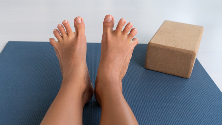 Legs stretched out on yoga mat 