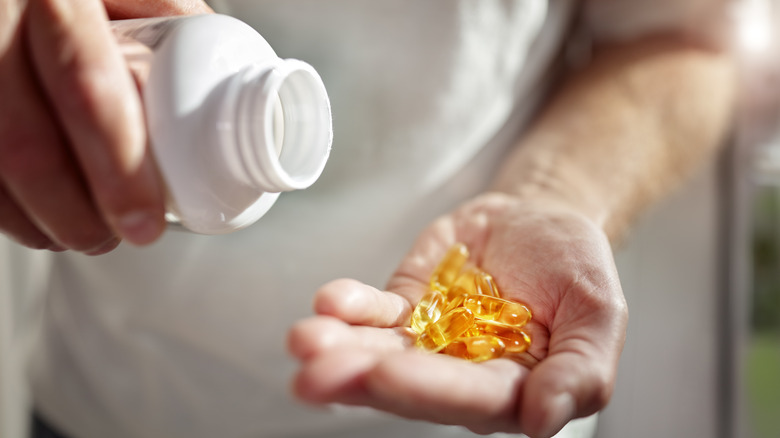 Person holding vitamin D capsules