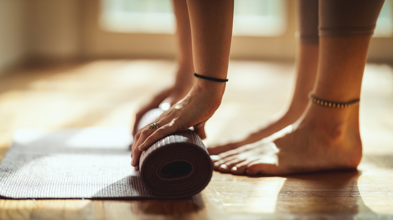 Woman rolling yoga mat