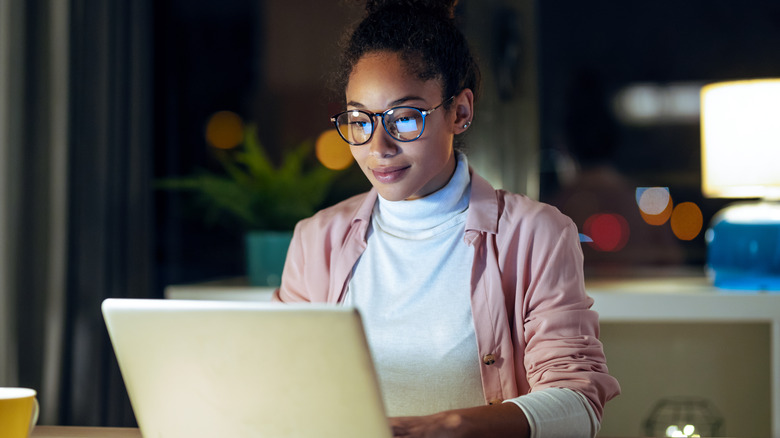 Black woman working on laptop at night