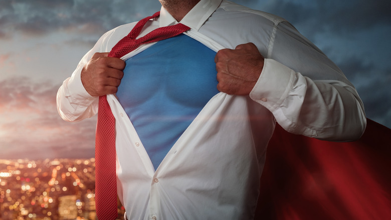 Man in shirt and tie wearing red cape like Superman