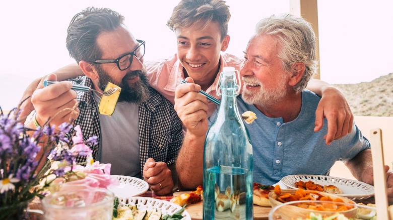 men laughing while eating healthy meal