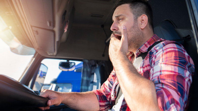 Truck driver yawning and looking haggard
