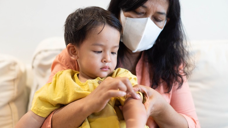 A mother holds a child who is sick