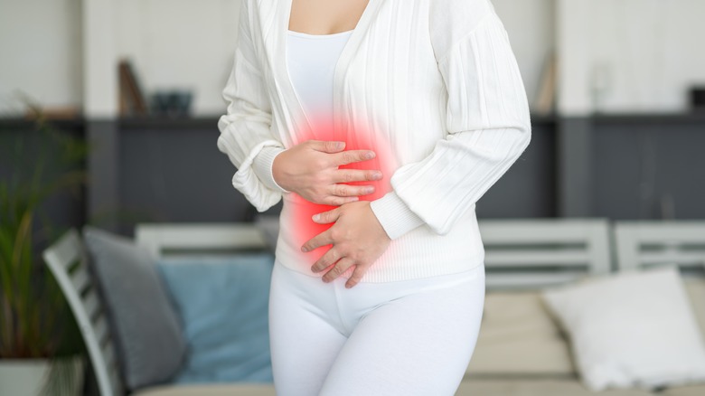 woman gripping stomach in pain