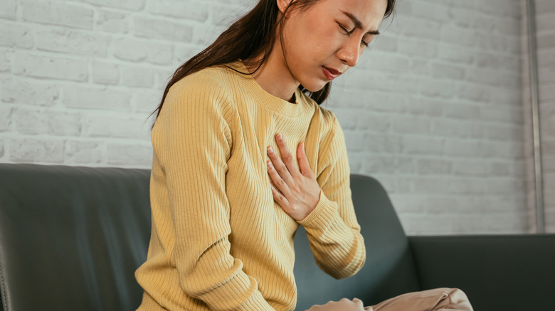 Woman experiencing indigestion and heartburn