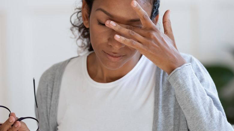 Woman rubbing eyes feeling dizzy