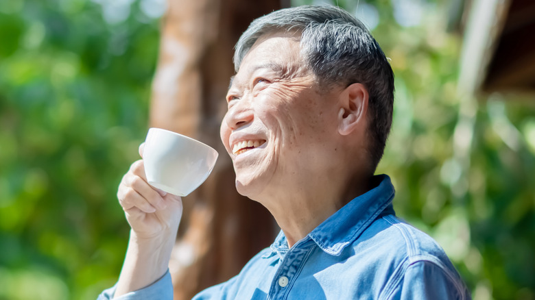 Smiling senior man holding mug