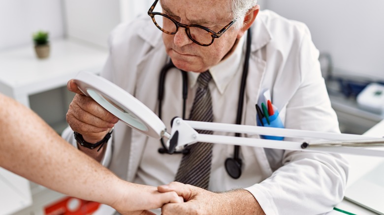 Doctor examining patient's skin