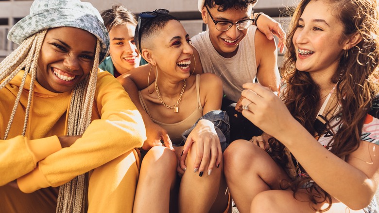 Young gen Z teens laughing together.