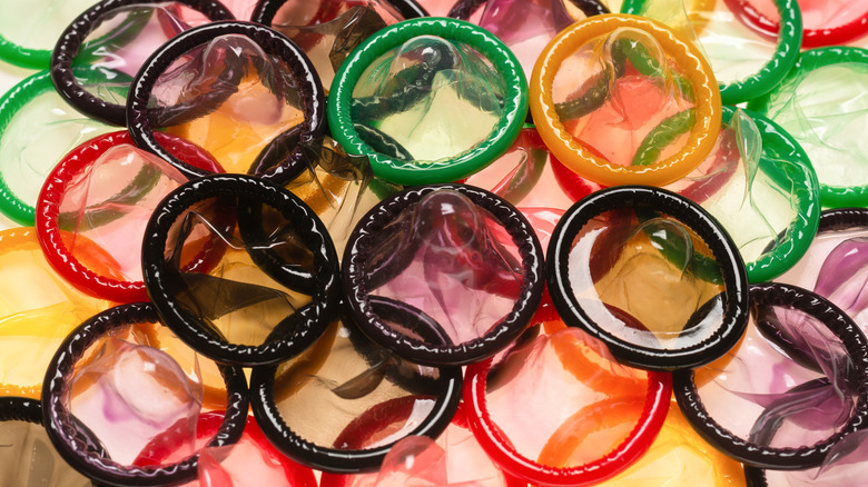 Multicolored condoms on a white table.