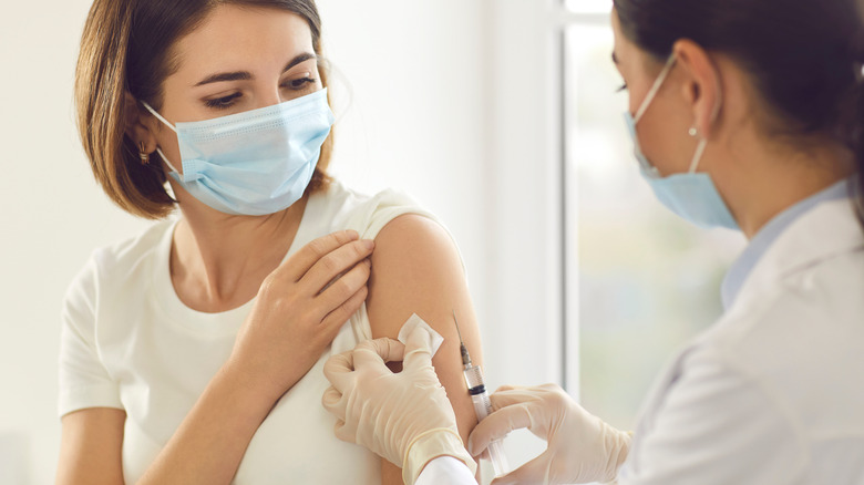 woman getting vaccinated by female doctor