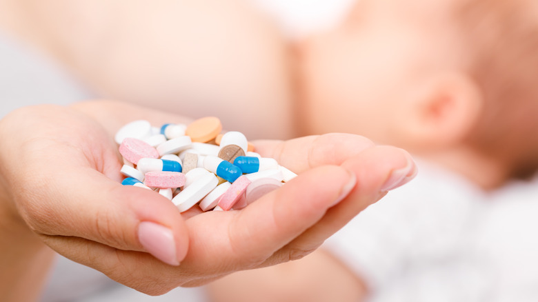Breastfeeding woman holding a variety of pills