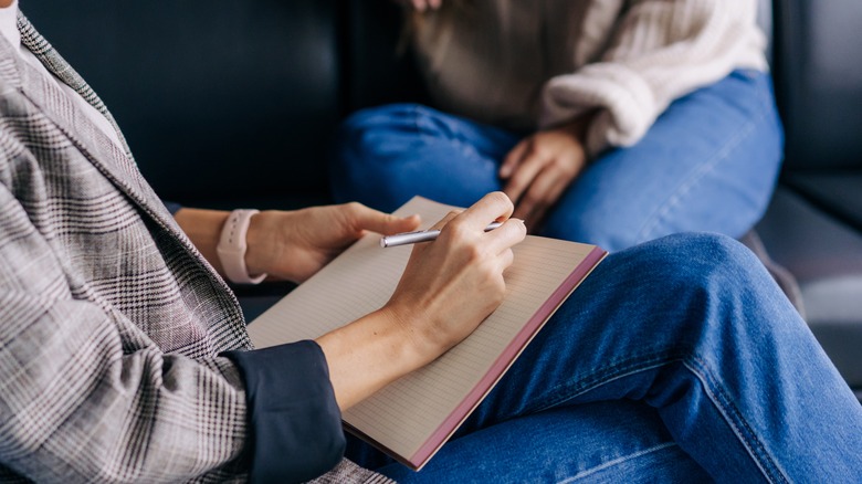 Therapist writing in notebook during session