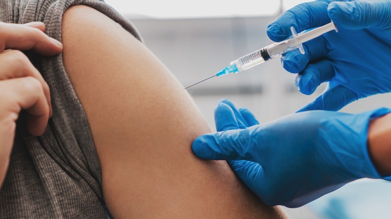 Healthcare provider injecting man's arm