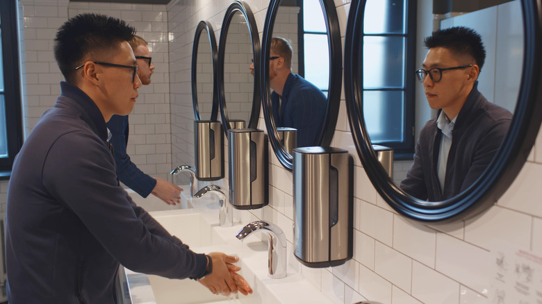 Men washing hands in the bathroom