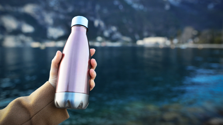 Person holding a reusable water bottle