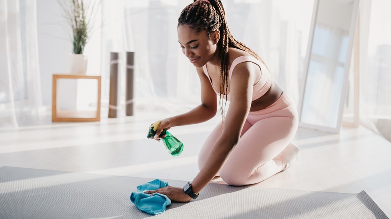woman cleaning yoga mat