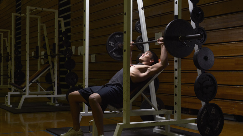 man doing chest press with barbell