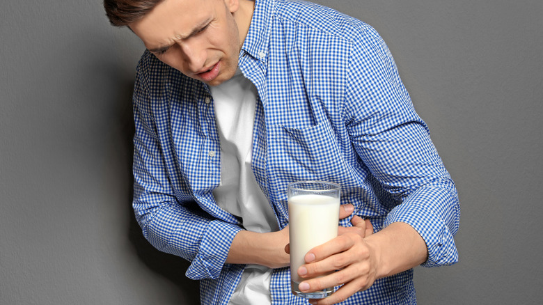 man with lactose intolerance holding milk