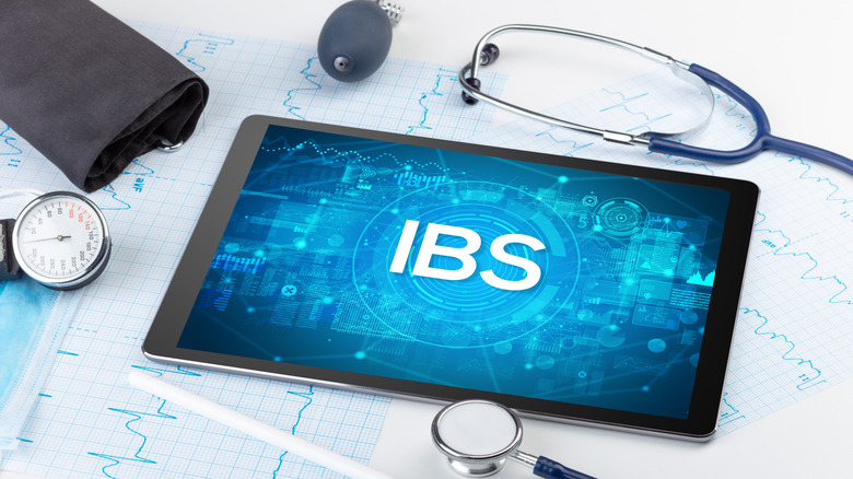 A tablet with the word "IBS' on it surrounded by medical equipment,