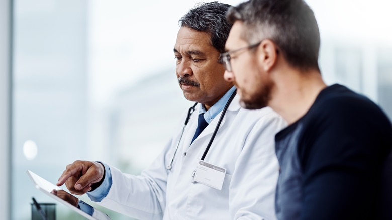 Man discussing his medical report with his doctor