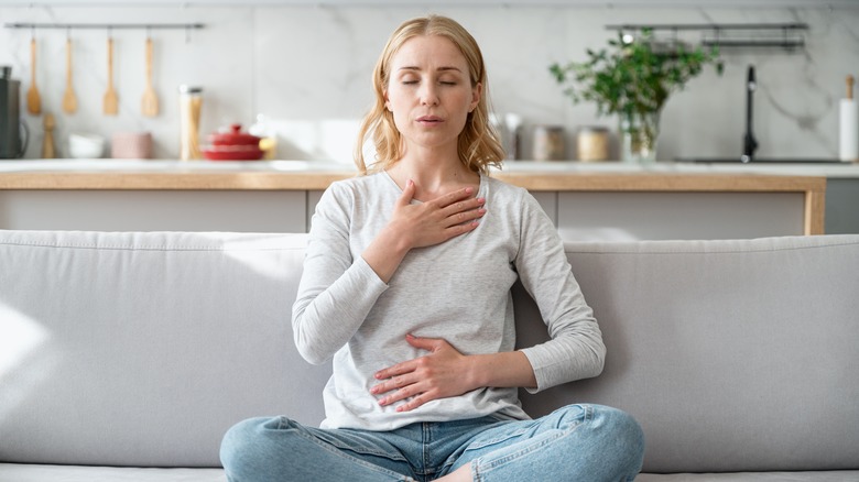 Woman breathing deeply at home