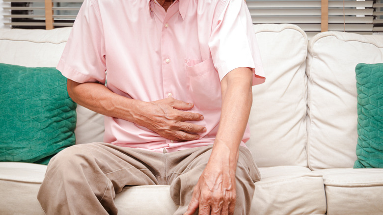 person sitting and holding stomach