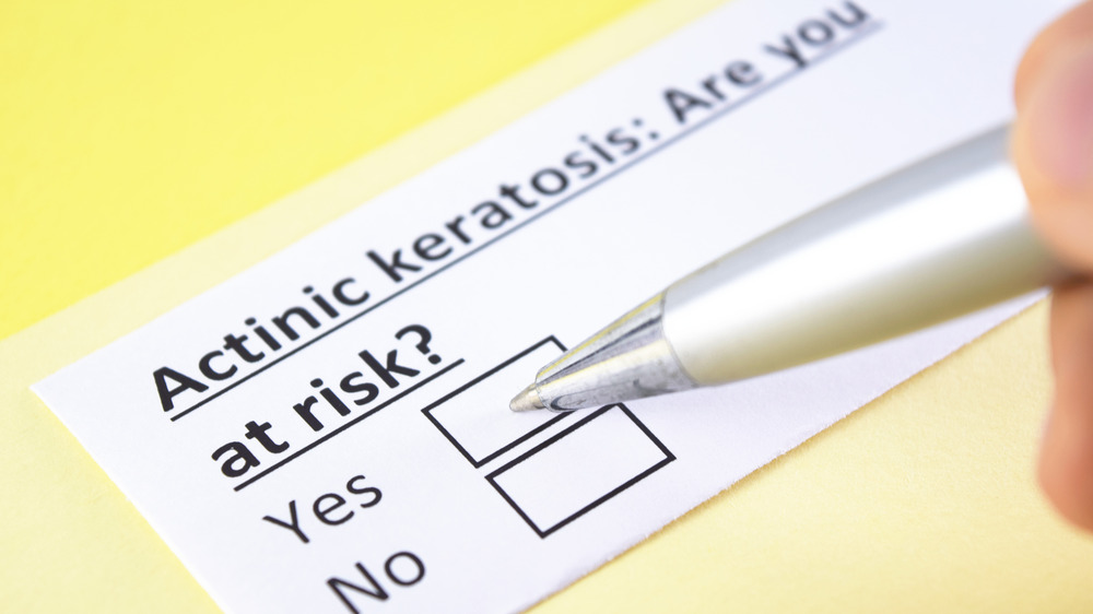 Close up of a pen over a piece of paper asking "Actinic keratosis: Are you at risk?" 