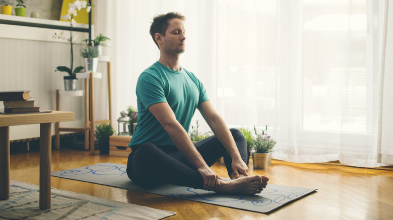 man stretching his legs in the living room