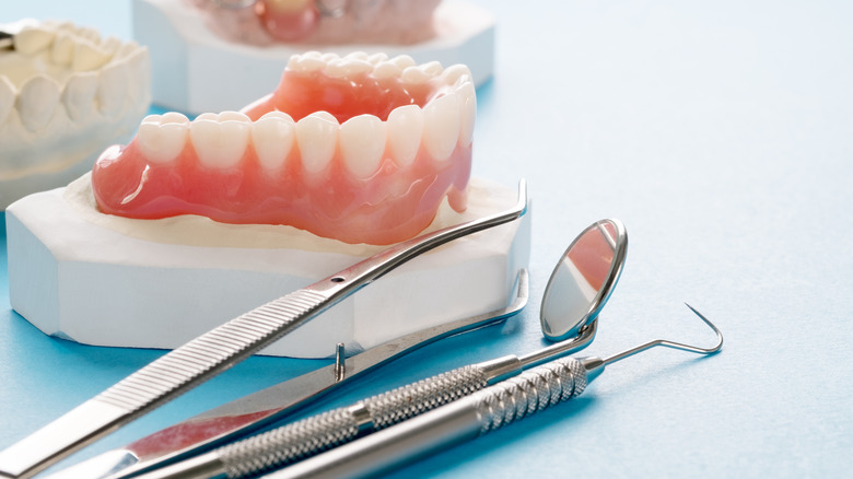 Close up of dentures and dental tools