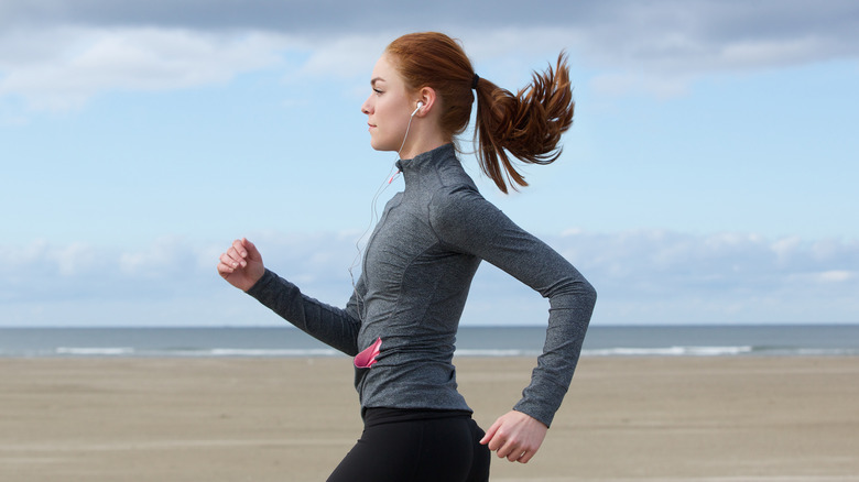 side view of a woman power walking on the beach