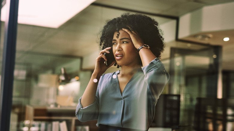 woman on phone holding head