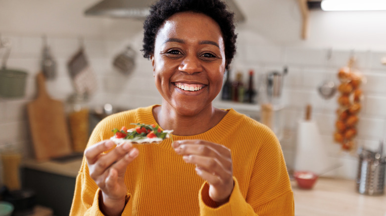 smiling woman holding cracker