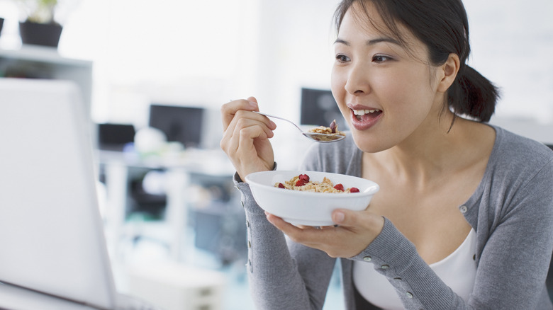 woman eating bowl of breakfast cereal