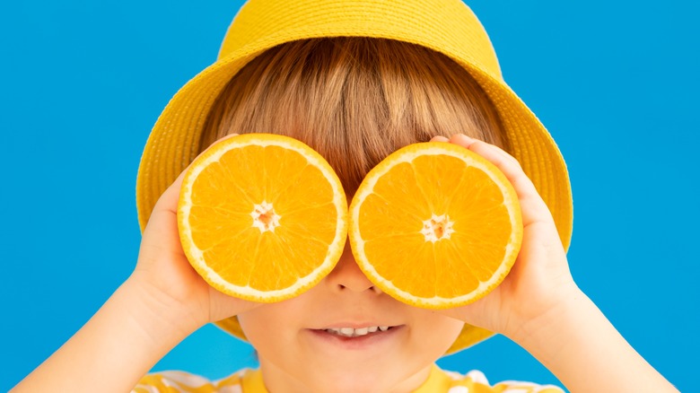 Child holding oranges