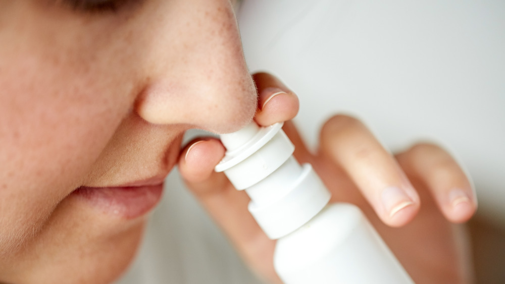 close up of person using nasal spray