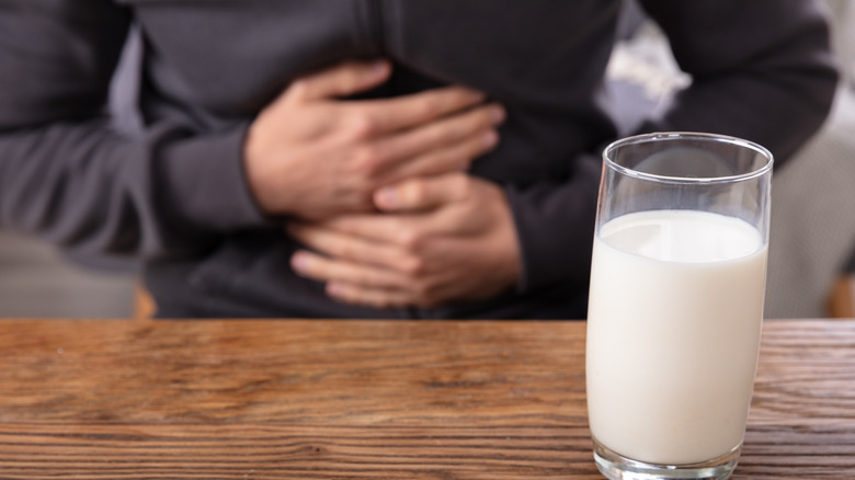 Hands on tummy behind milk glass