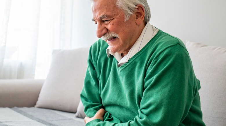 Elderly man hunched in pain