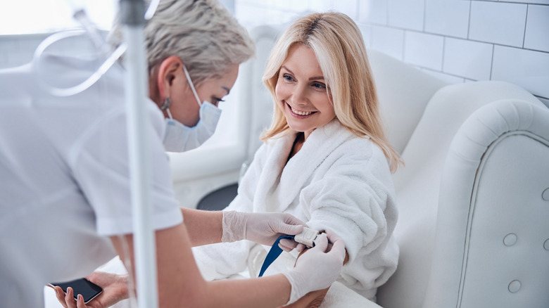 A nurse administering an IV to a patient