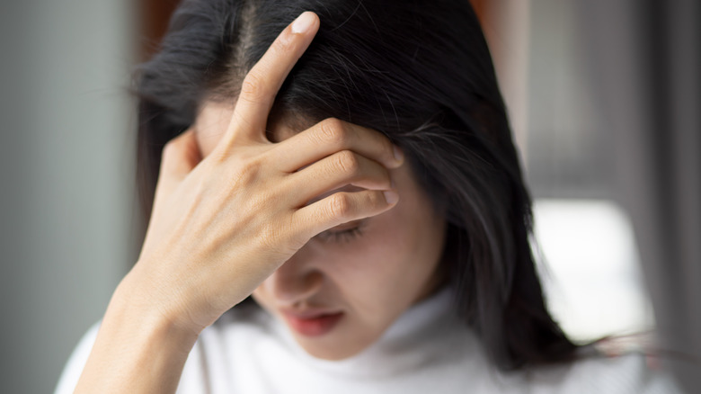 woman with headache holding head